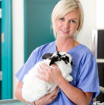 A portrait of a female vet holding a rabbit