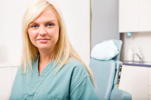 A portrait of a dental hygienist in front of a dental chair