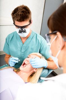 A dentist with assistant working on a patient