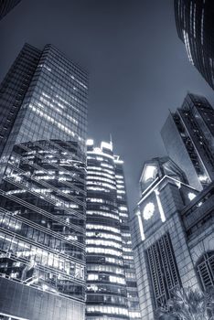 Modern business center at night with blue tone.