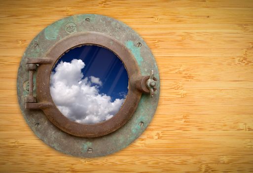 Antique Porthole on Bamboo Wall with View of Beautiful Blue Sky and Clouds.