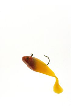 A red hed swimbait floating on white