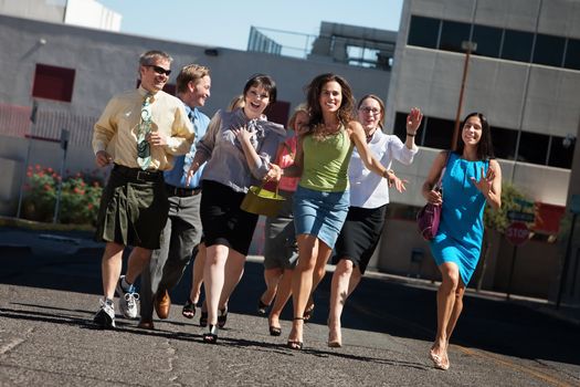 Happy group of business people running on city street