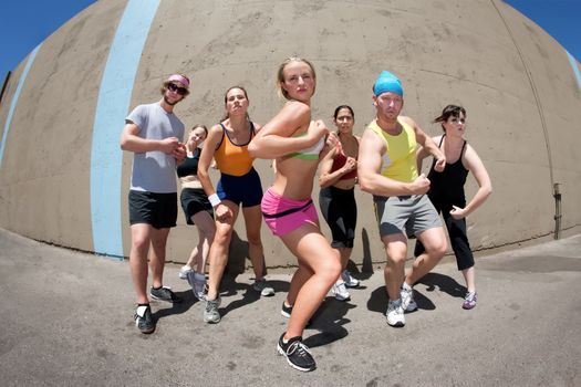 Pretty female runner poses with fellow athletes