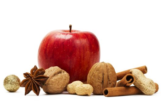 red apple, star anise, cinnamon sticks and some nuts  on white background