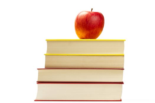 a red apple on top of some books isolated on white background