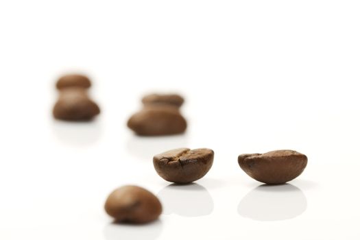 focus on two coffee beans between others on white background