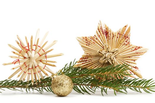 two straw stars and a glitter christmas ball and a branch on white background