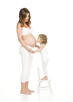 Pregnant woman with her daughter standing on a chair