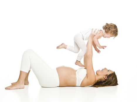 Pregnant woman with her daughter laying on the floor isolated on white background