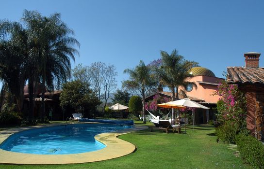 Hotel with swimming pool and palms in the garden