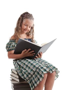 Little girl with pigtails reading a book, isolated on white background, focus on book 