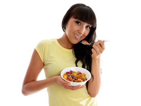 A beautiful smiling woman eating a healthy breakfast of cereals, nuts and fruit.  White background.