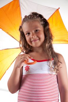 Little girl wearing summer dress and holding umbrella, studio shot 