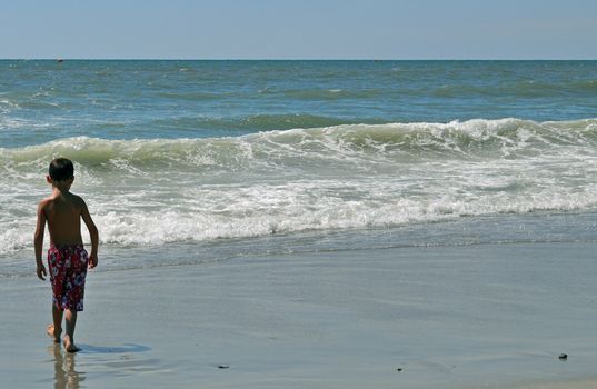 Boy walks toward the waves