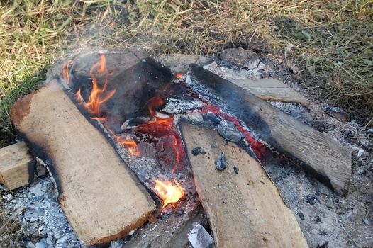 Campfire burns in the grass