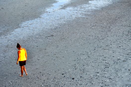 Lady in yellow looks for shells