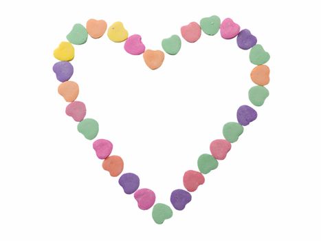 Heart shape made of small candy hearts isolated on white