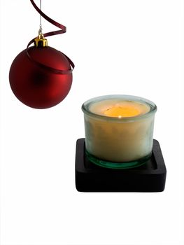 Christmas ornament and lit candle isolated on white