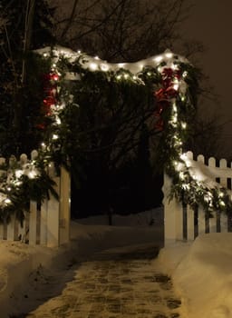 Walkway with fence lit up with christmas lights