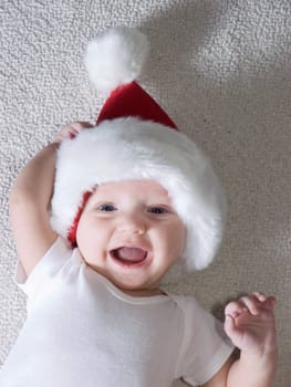 Young baby boy wearing santa hat and smiling