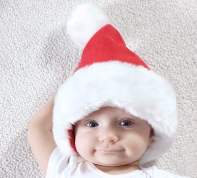 Young baby boy wearing santa hat and smiling