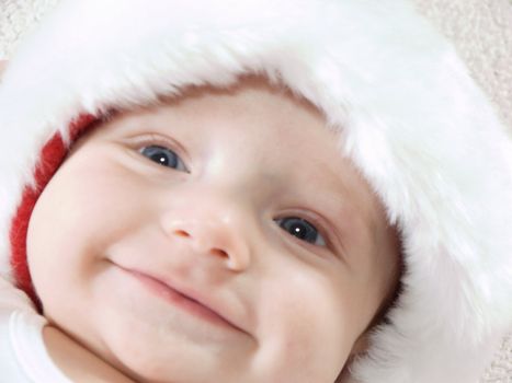 Young baby boy wearing santa hat and smiling