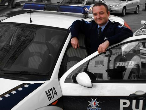 Police officer near squad car of the Mobile Squad - Malta Police Force      