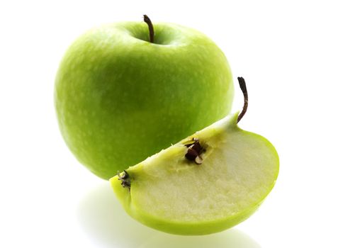 green fresh ripe apple with a slice over white background. Shallow DOF focus on pulp