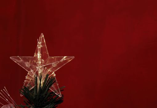 Details of a fibre-optic decorated Christmas Tree against a red wall