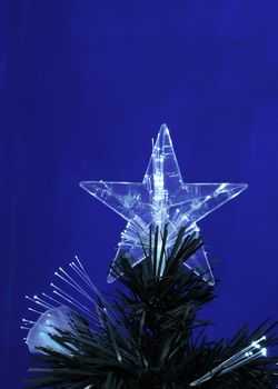 Details of a fibre-optic decorated Christmas Tree against a red wall