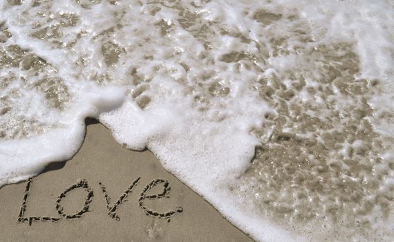 Love written in the sand with wave 4