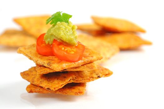 Delicious crackers topped with guacamole and tomato.