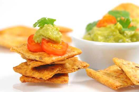 Cracker topped with tomato and fresh made guacamole.