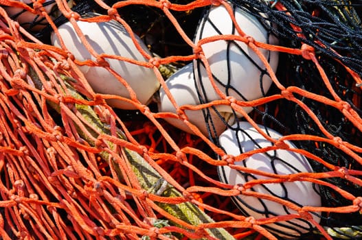 Close-up fishing net with floats on the background.