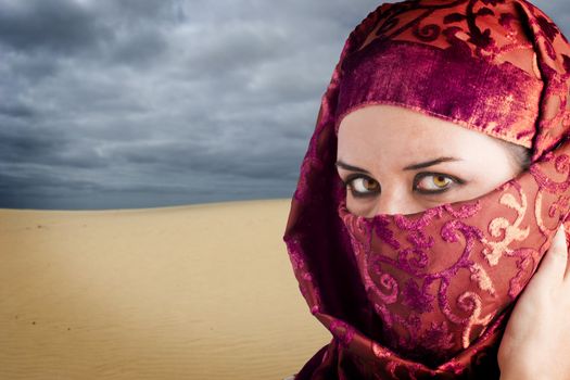 woman dressed in Arab costume, desert in the background