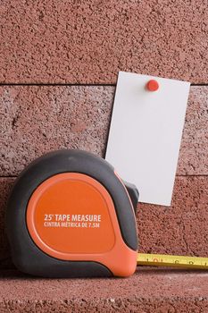 White piece of paper next to a tape measure. Add your text to the paper.