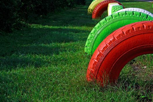 Differently painted wheels from rubber fixed at playground