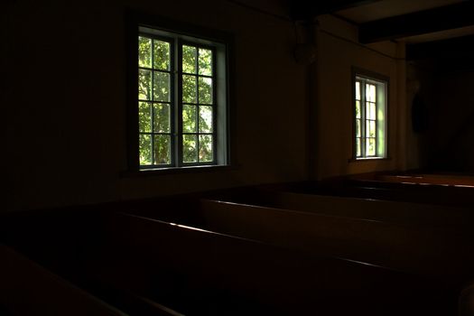 Dark inner rooms of church lighted by windows