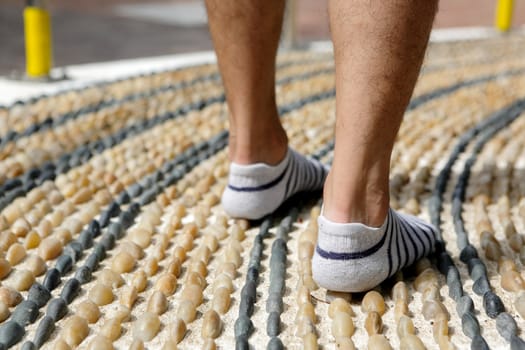 walking on foot message pebble stone path