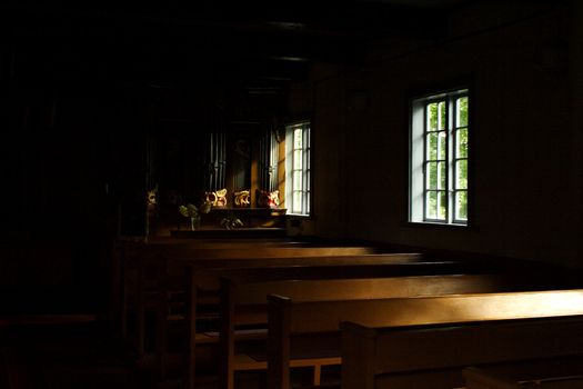 Gloomy inner rooms of church lighted by windows