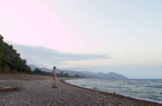 Caucasian boy look at the water at evening