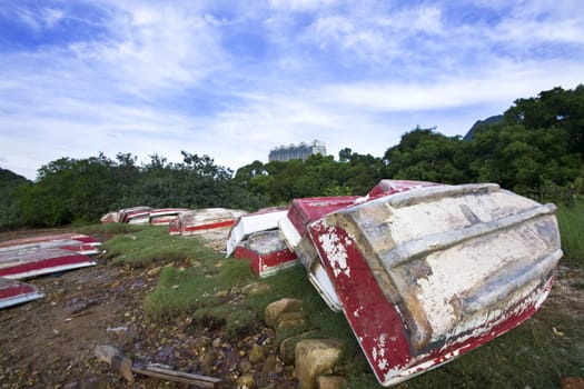 Old fish-boat on sandy beach and blue sky