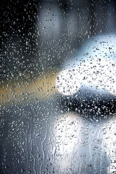 View of a glass with many droplets of water lit by a passing car.