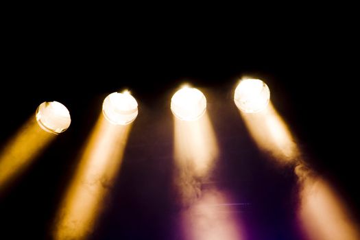 Close up view of various spotlights lit on a stage.
