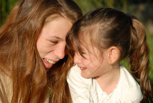 two smiling sisters: teenager and little girl

