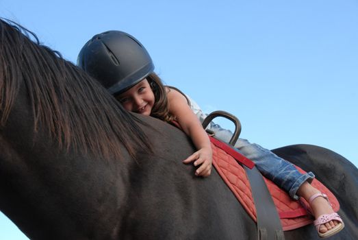 very young little girl on her black stallion

