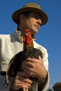 beautiful french man with hat and his colorful chicken