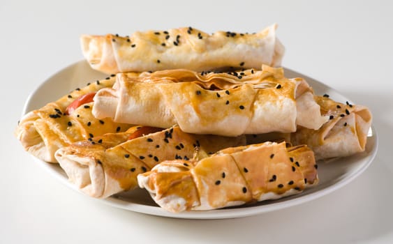 Scone with sesame seeds on a white plate.