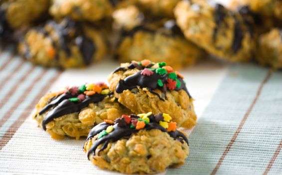 Cornflakes cereal cookies with chocolate sauce and colorful sprinkles